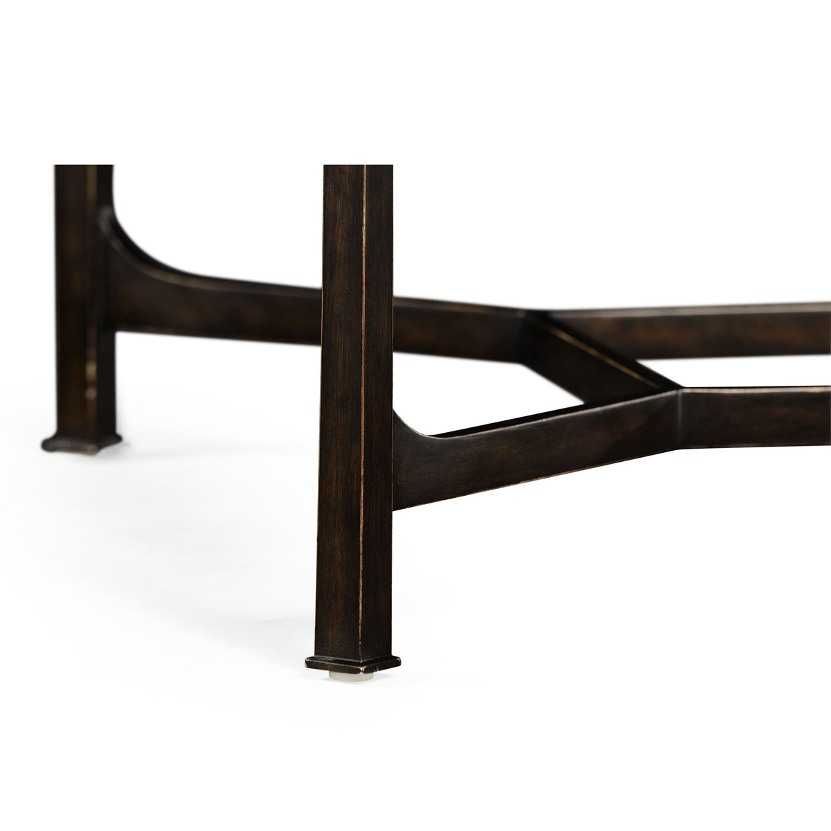 Low-angle detail of robust square bronze leg with beveled edge and X-shaped brace on modern coffee table