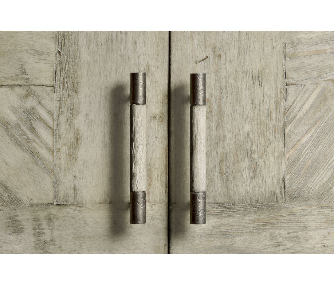 Detail shot of vertical wood and metal handles on rustic grey chevron parquetry doors