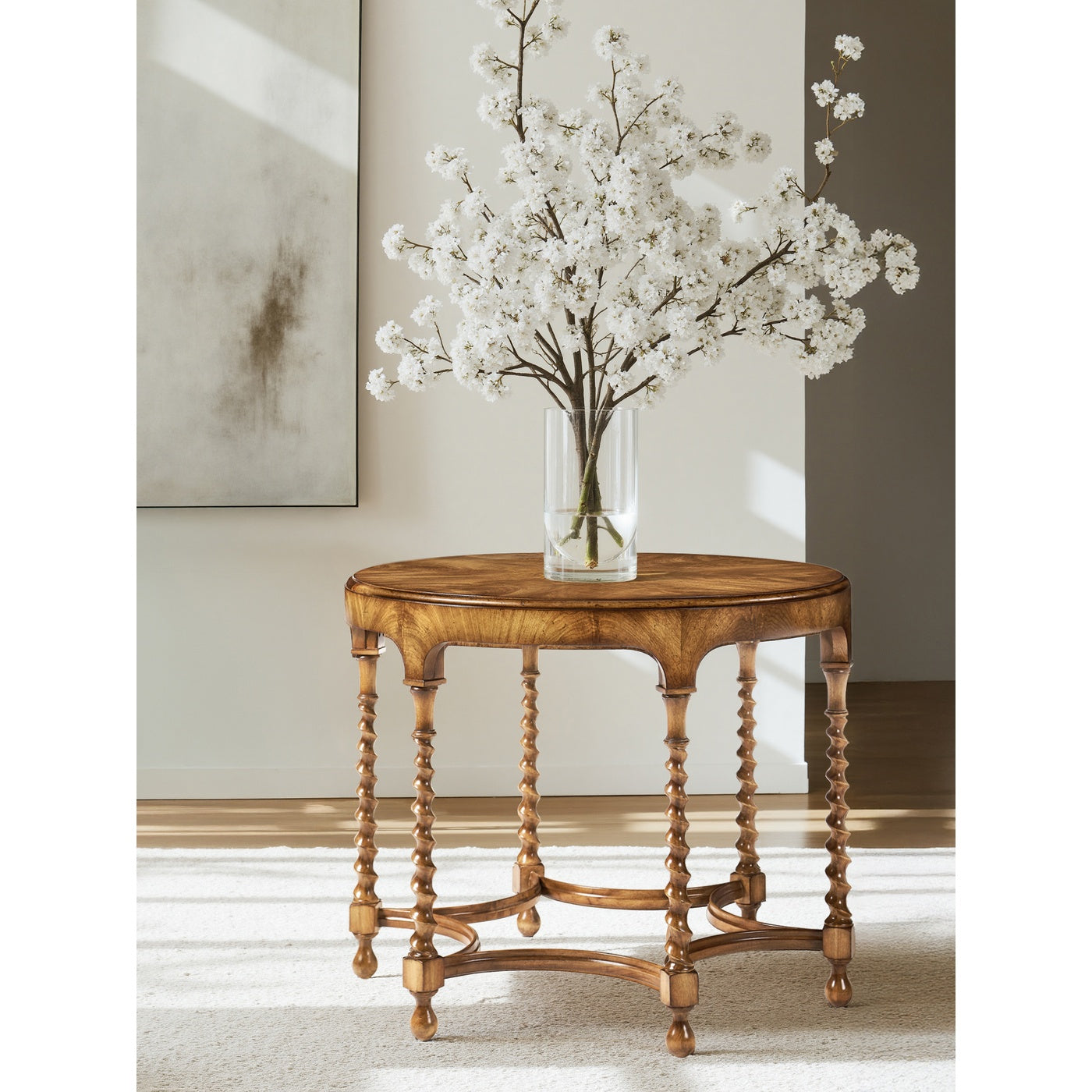 Caramel walnut round coffee table styled in modern living room with glass vase on beige rug