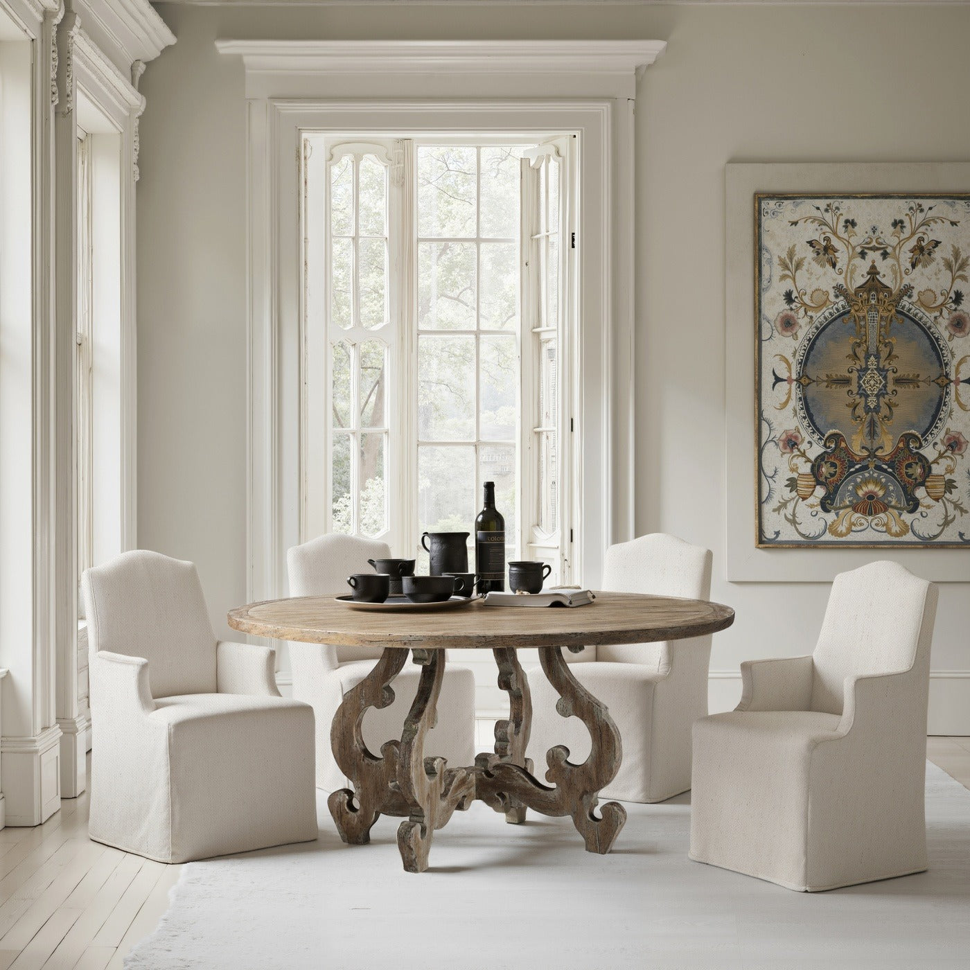 Lifestyle shot of Jonathan Charles Caldera round dining table styled with dinnerware in traditional elegant room