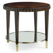 A round wooden accent table with a dark brown wood top, fluted apron detail, four tapered legs, and a lower glass shelf with a brass metal rim and gold-toned feet, shown on a white background.