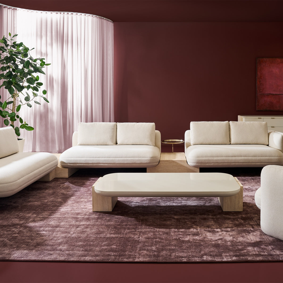 Caracole rectangular coffee table with glossy light top and Travertine legs in modern burgundy living room
