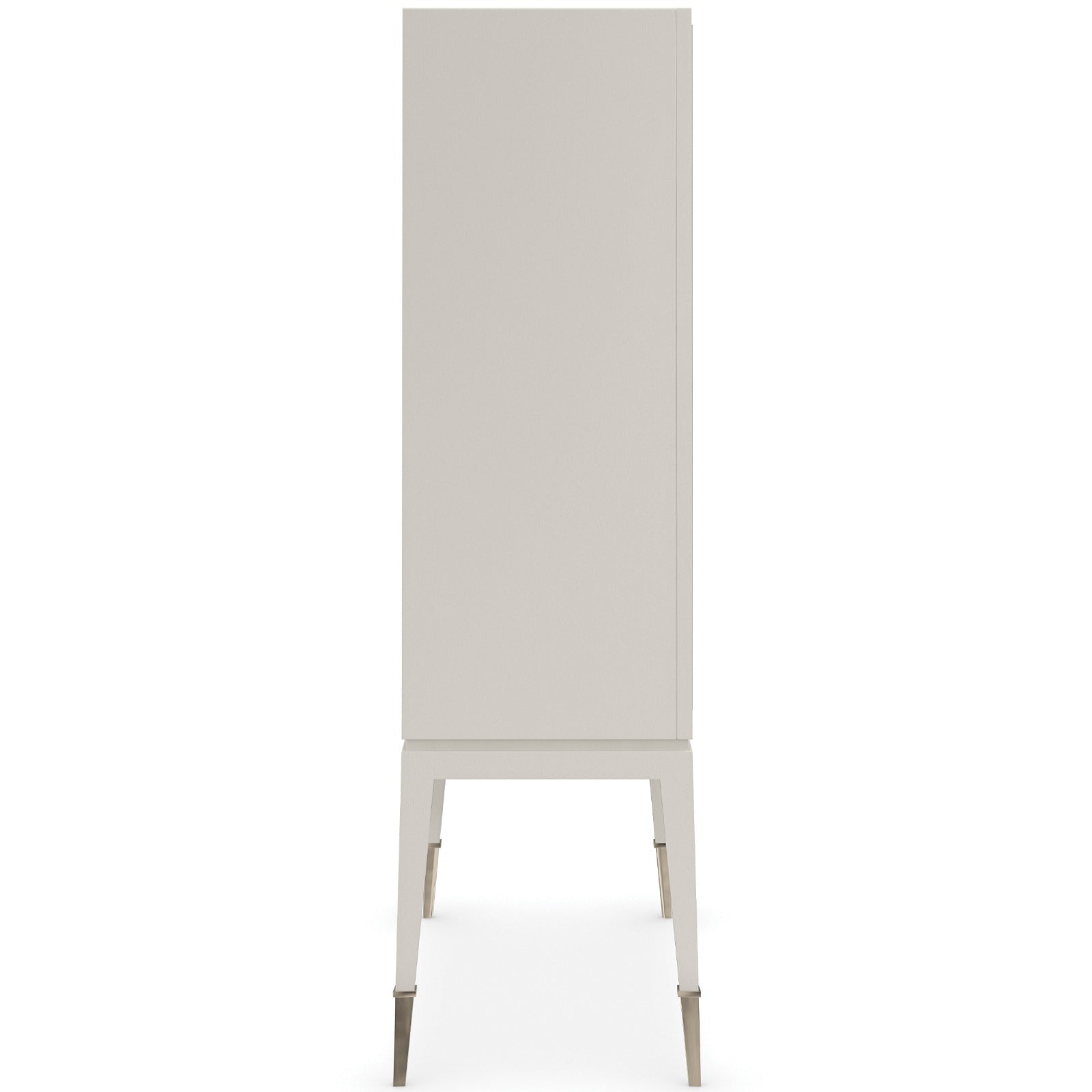 Side profile of Caracole Currents tall storage cabinet showing seamless Almond Milk painted case, tapered legs, and gold-toned metal caps
