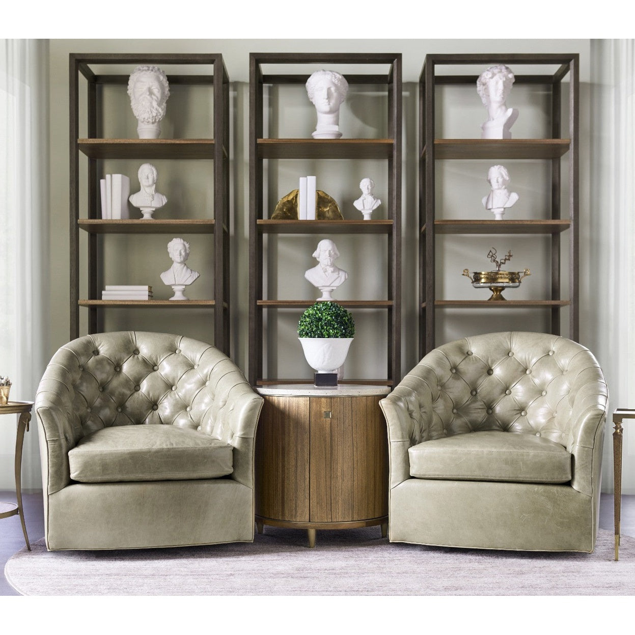 Lifestyle shot of Jonathan Charles Hamilton round side table with brass trim between olive leather armchairs in living room