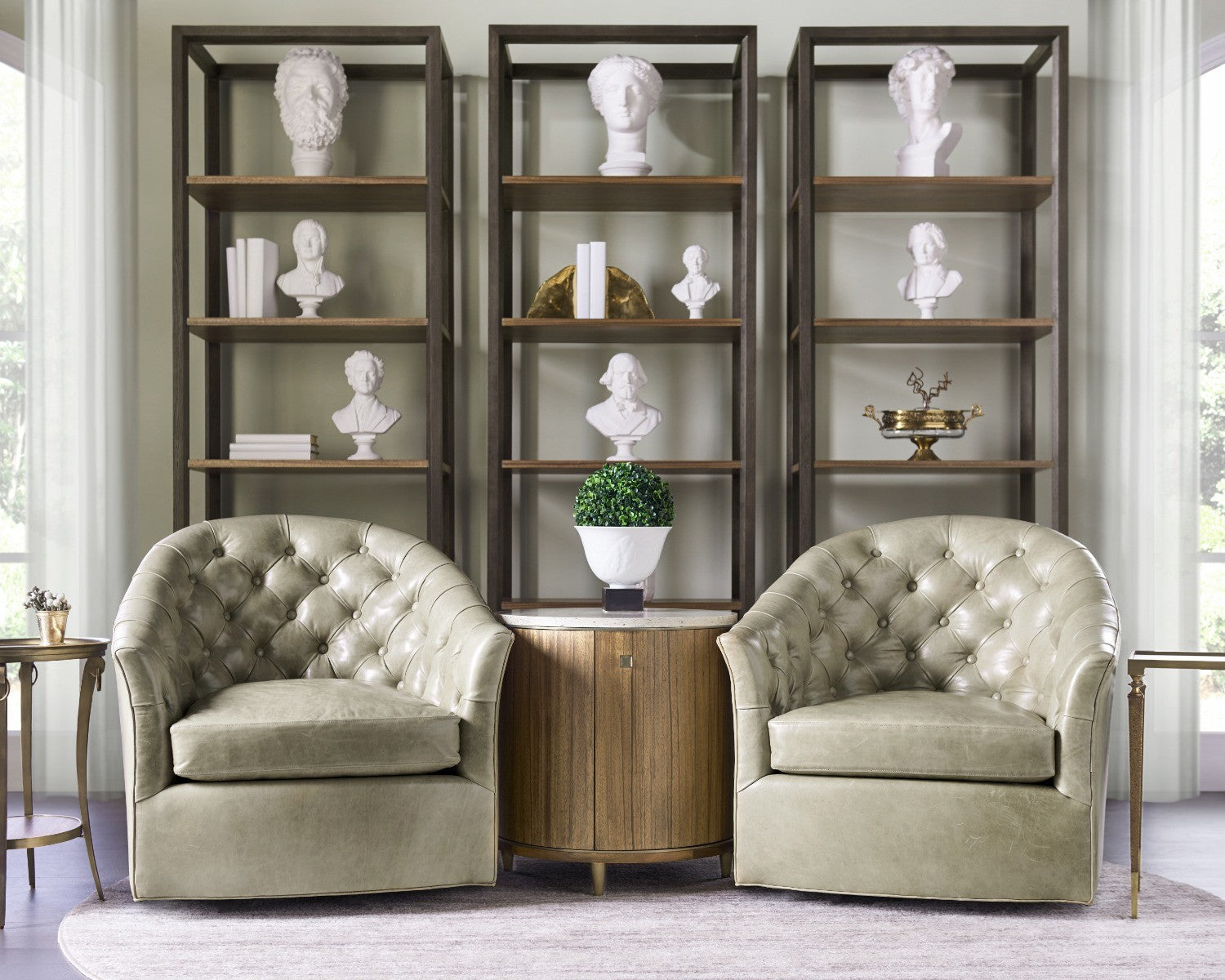 Lifestyle shot of Jonathan Charles Hamilton round side table with brass trim between olive leather armchairs in living room
