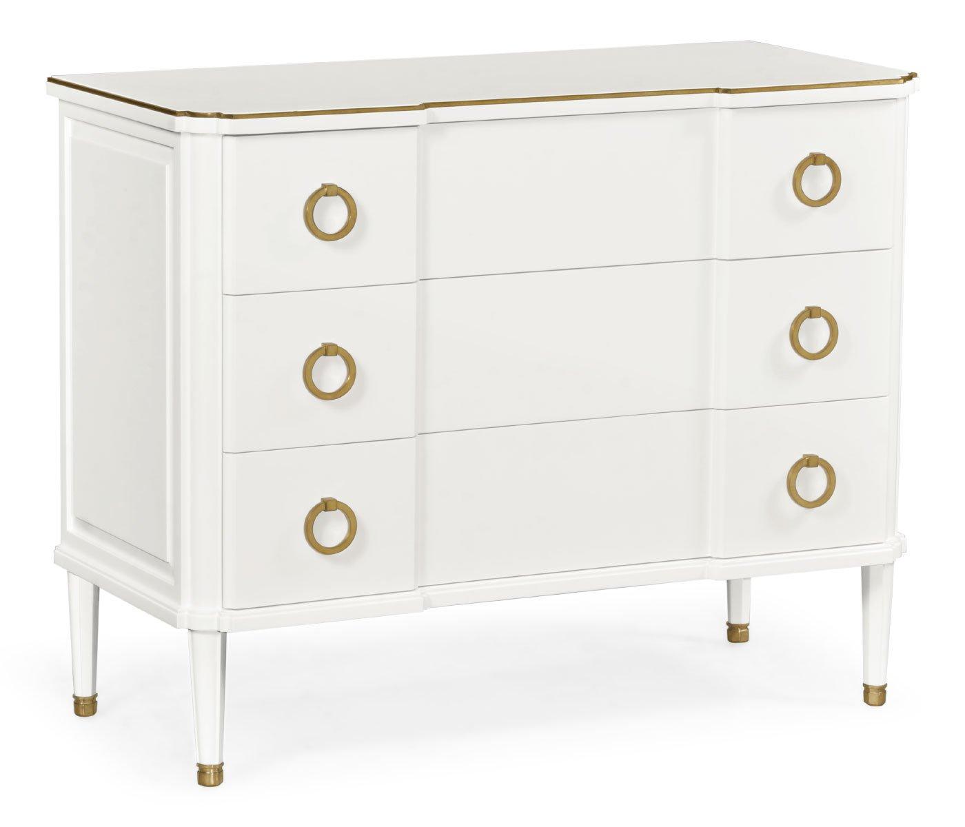 Full view of painted ivory chest of drawers with brass trim and tapered legs