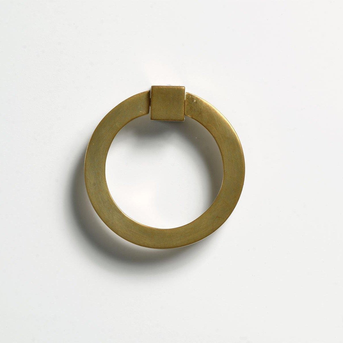 Close-up of brushed gold round brass ring pull hardware with square mounting bracket