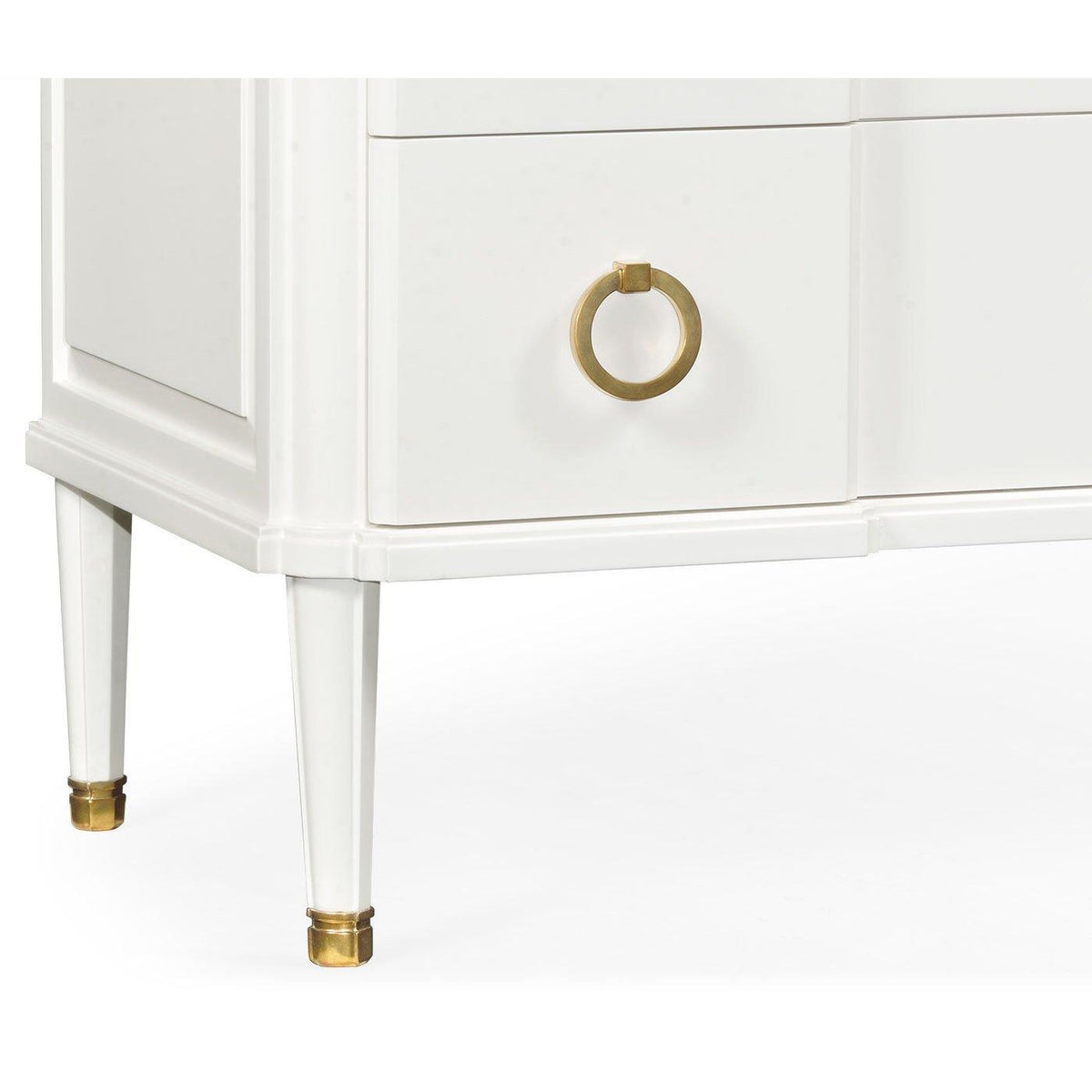 Tapered white leg with polished brass cap on Jonathan Charles ivory chest of drawers