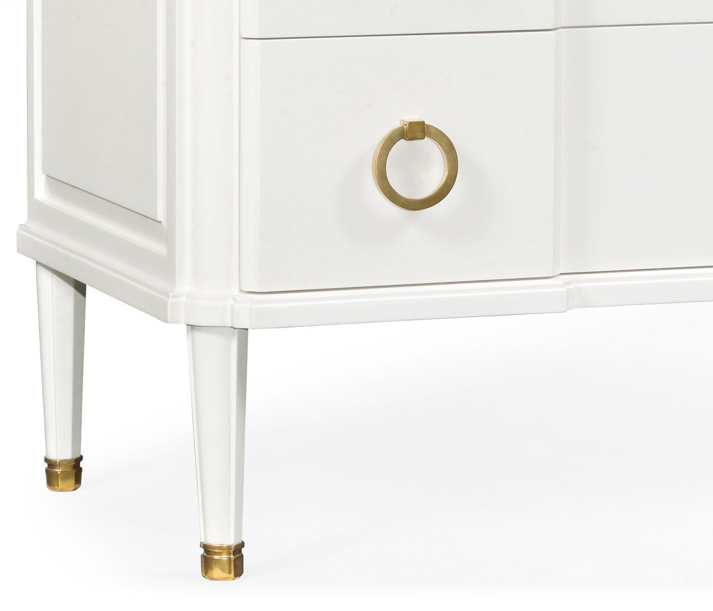 Tapered white leg with polished brass cap on Jonathan Charles ivory chest of drawers