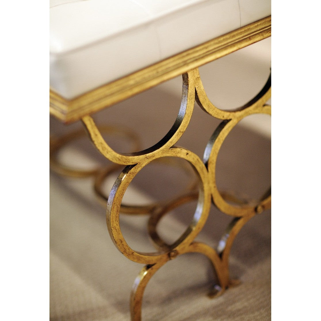 Extreme close-up of distressed gold finish and hand-forged details on Jonathan Charles Bench Circles metal frame