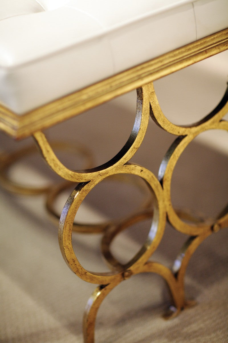 Extreme close-up of distressed gold finish and hand-forged details on Jonathan Charles Bench Circles metal frame