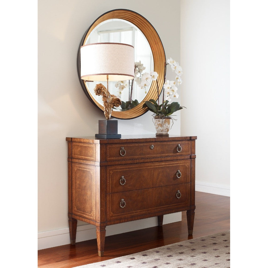 Walnut French Empire chest of three drawers with brass sabots and geometric inlay styled beside mirror