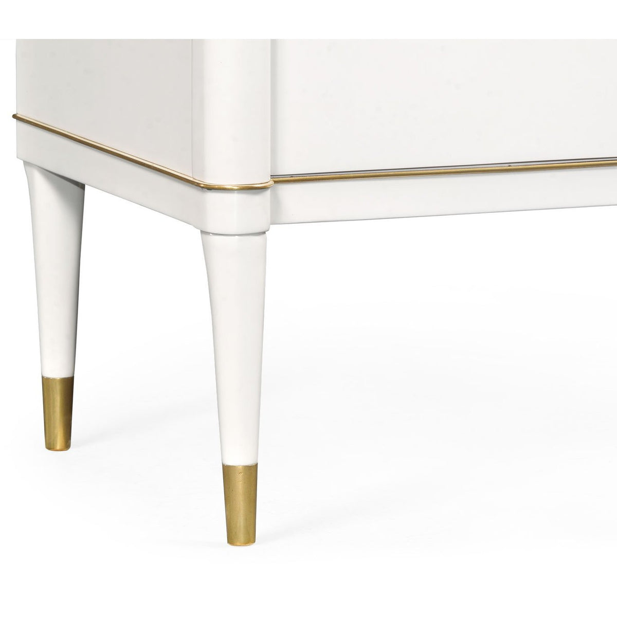Close-up of tapered white legs with gold caps on Jonathan Charles ivory chest of drawers