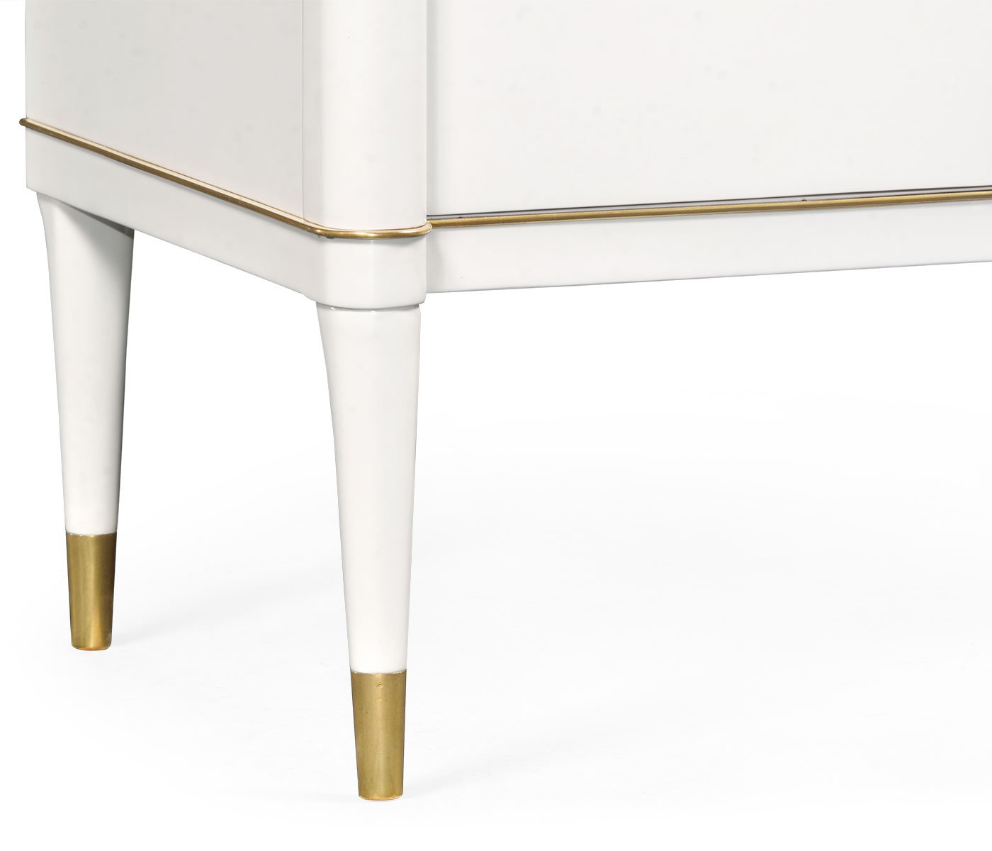 Close-up of tapered white legs with gold caps on Jonathan Charles ivory chest of drawers